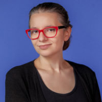 Picture of a woman in ponytail wearing red glasses